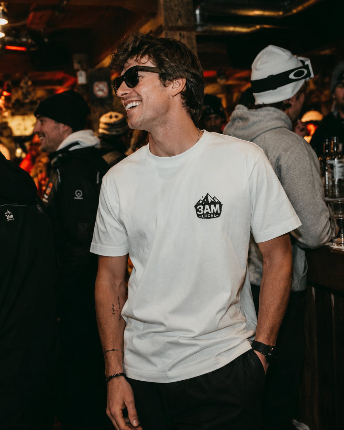 Man in the Double Black Diamond tee at a dim crowded bar