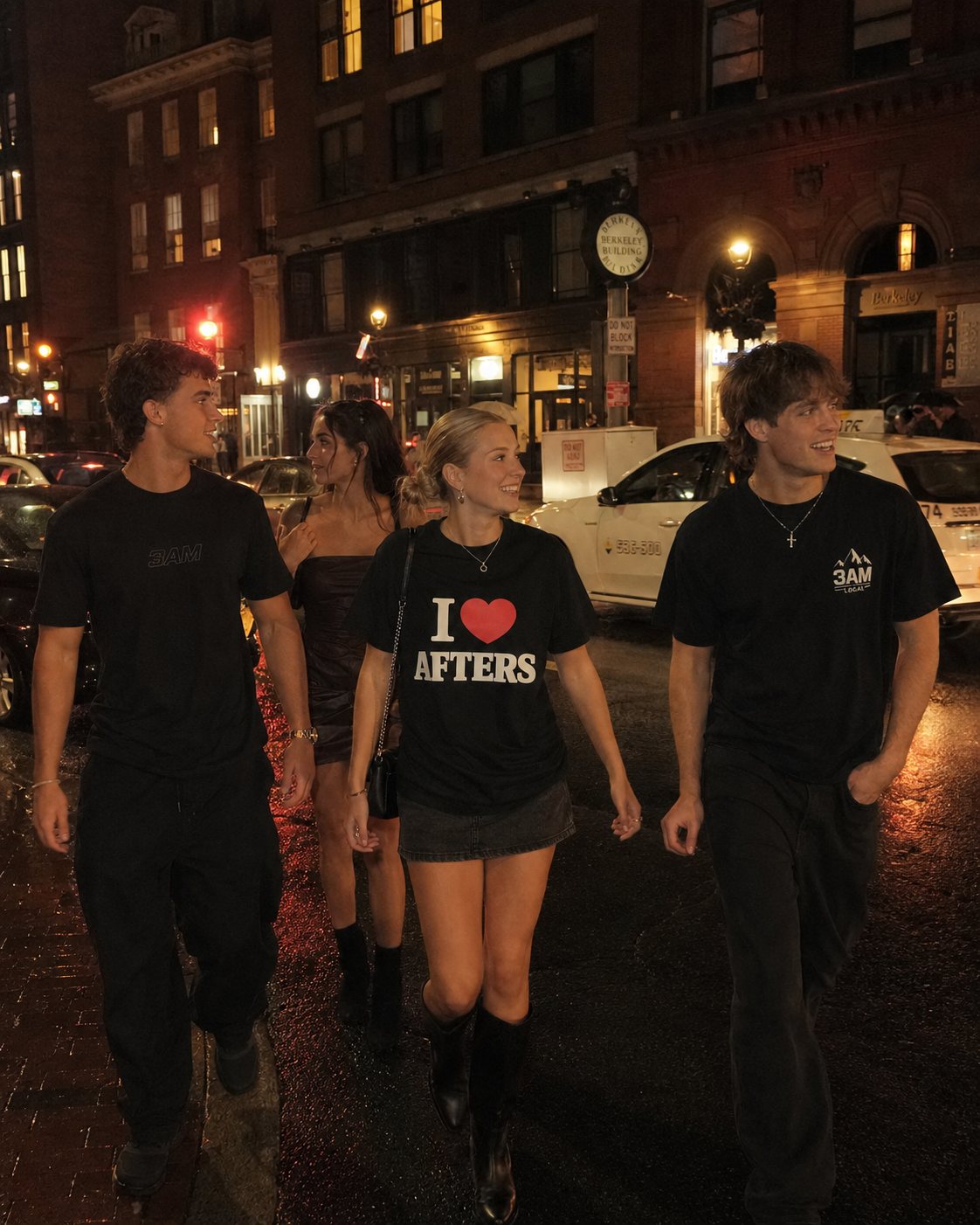 Three friends walking a Boston street at night, center in the I heart Afters tee