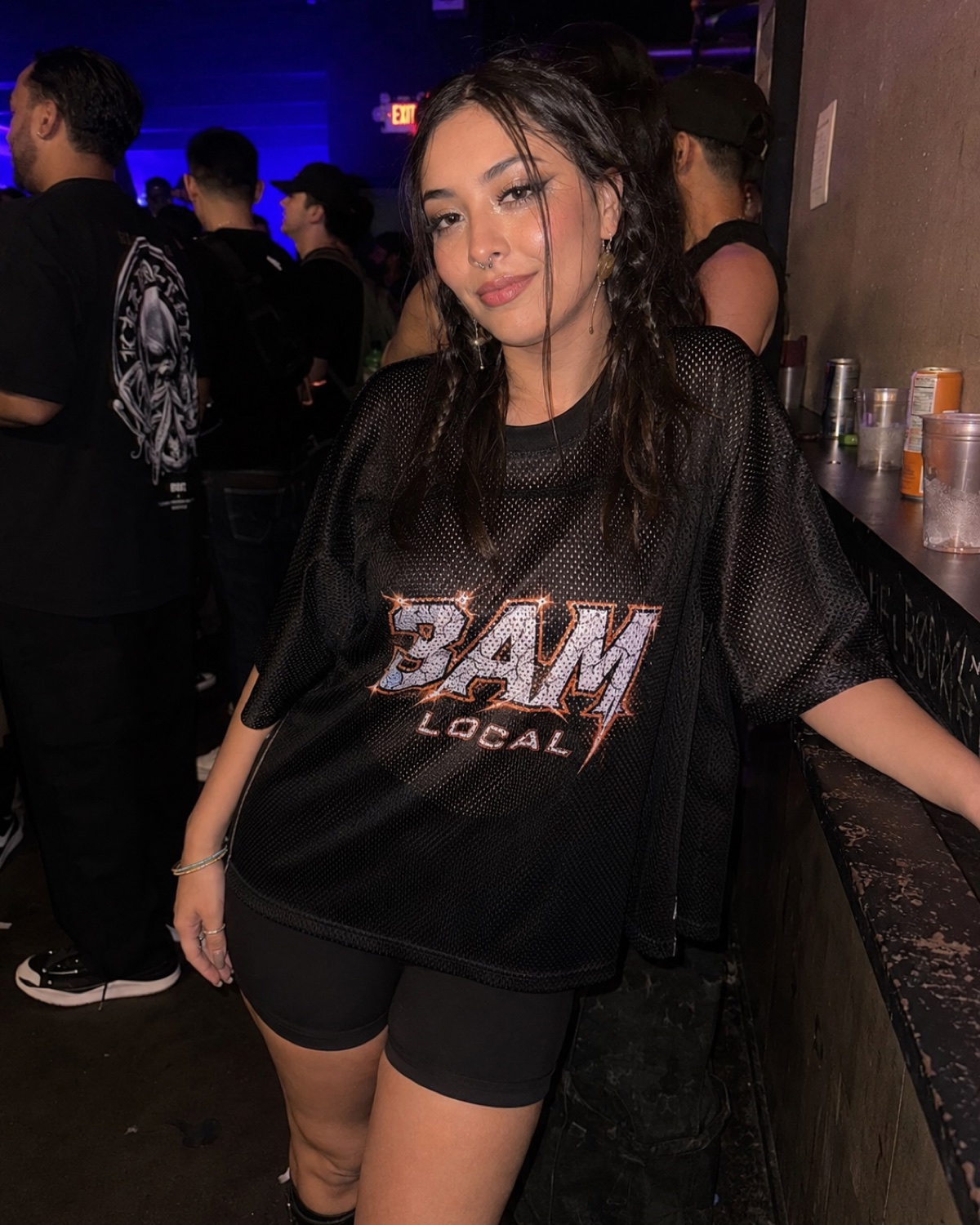 Woman in the 3AM Local home jersey at the bar at a club