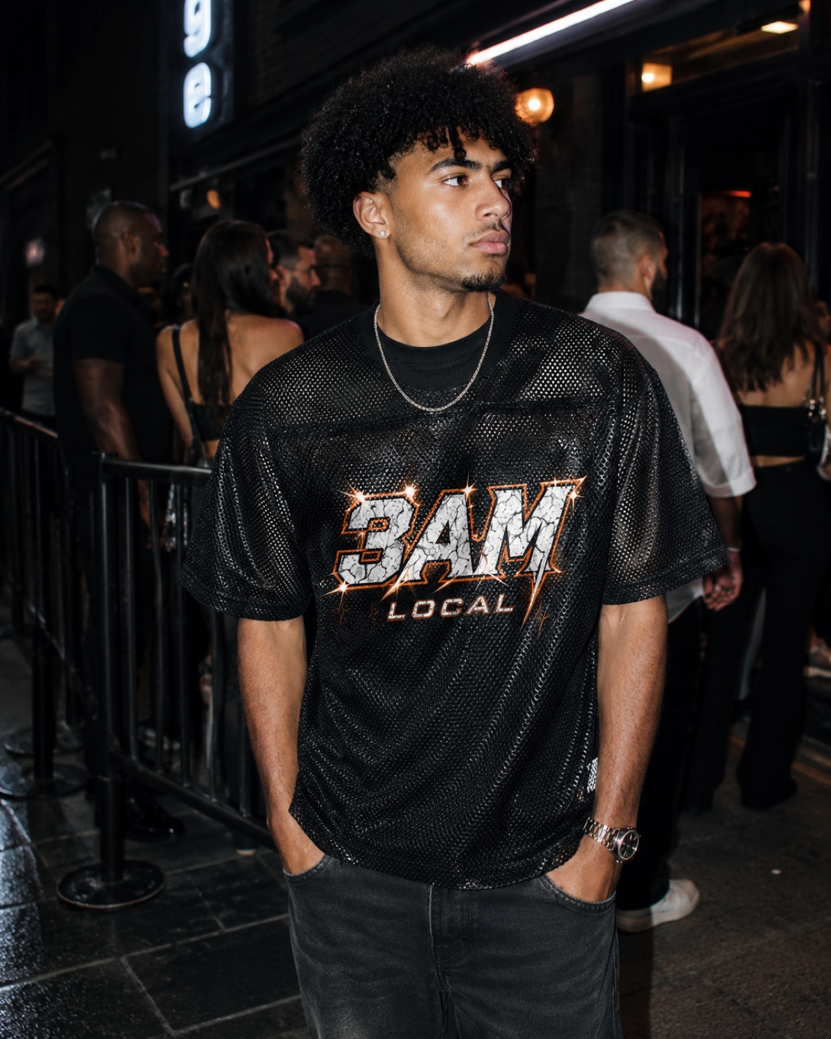 Man in the 3AM Local home jersey outside a club at night