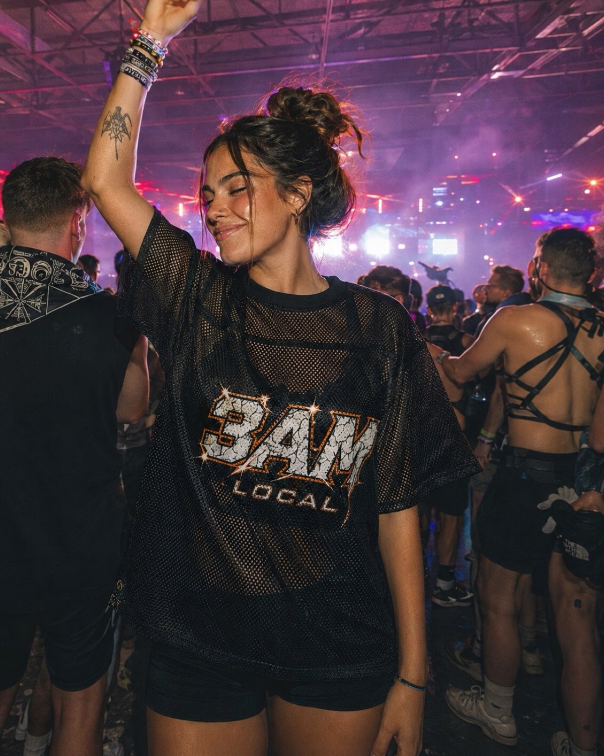 Woman dancing in the 3AM Local home jersey on a packed festival floor