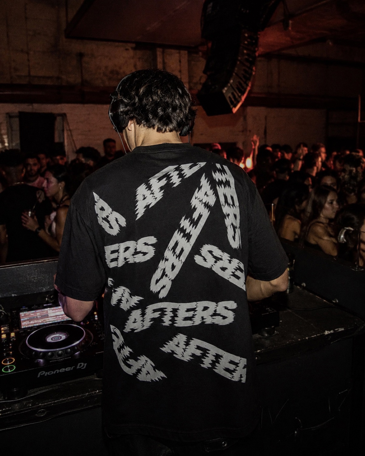 Too Far Gone tee worn by a DJ behind the decks at a warehouse party